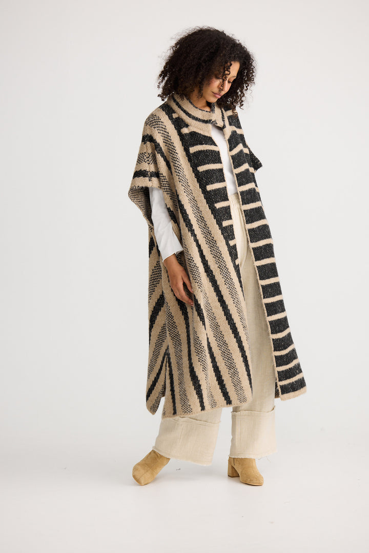 Model wearing black w cedar stripe Mirador Knit Cape, angled front view on white background