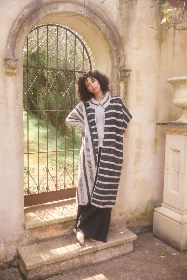 Model wearing black w cedar stripe Mirador Knit Cape, lifestyle close-up view