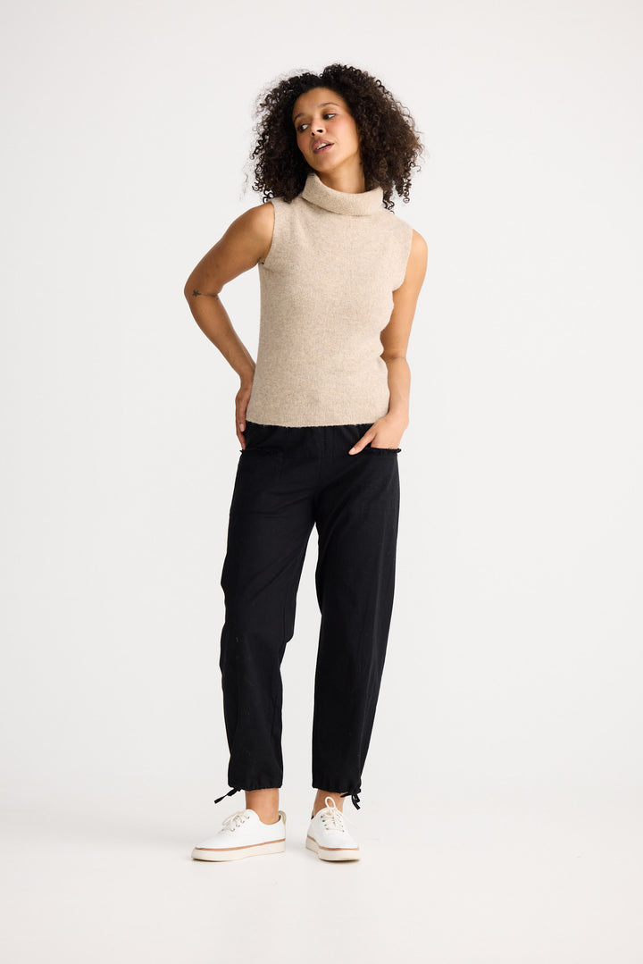 Model wearing oatmeal Lucerne Knit Top, side view on white background