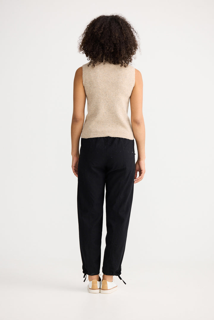 Model wearing oatmeal Lucerne Knit Top, back view on white background