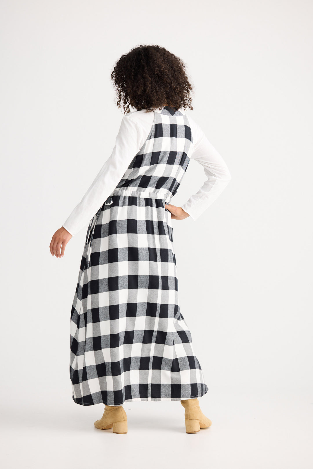 Person wearing a long black and white checkered dress on a white background