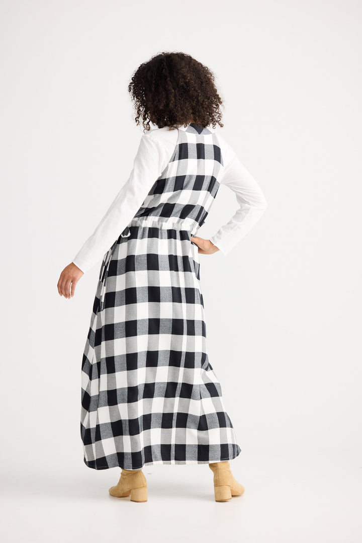 Person wearing a long black and white checkered dress on a white background