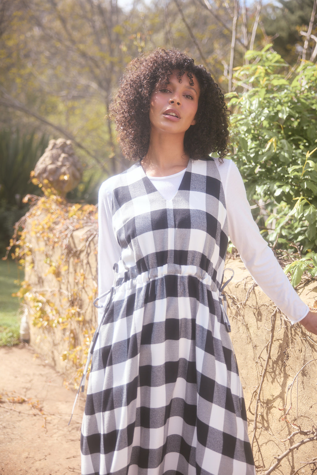 Woman wearing a black and white checkered dress in an outdoor setting
