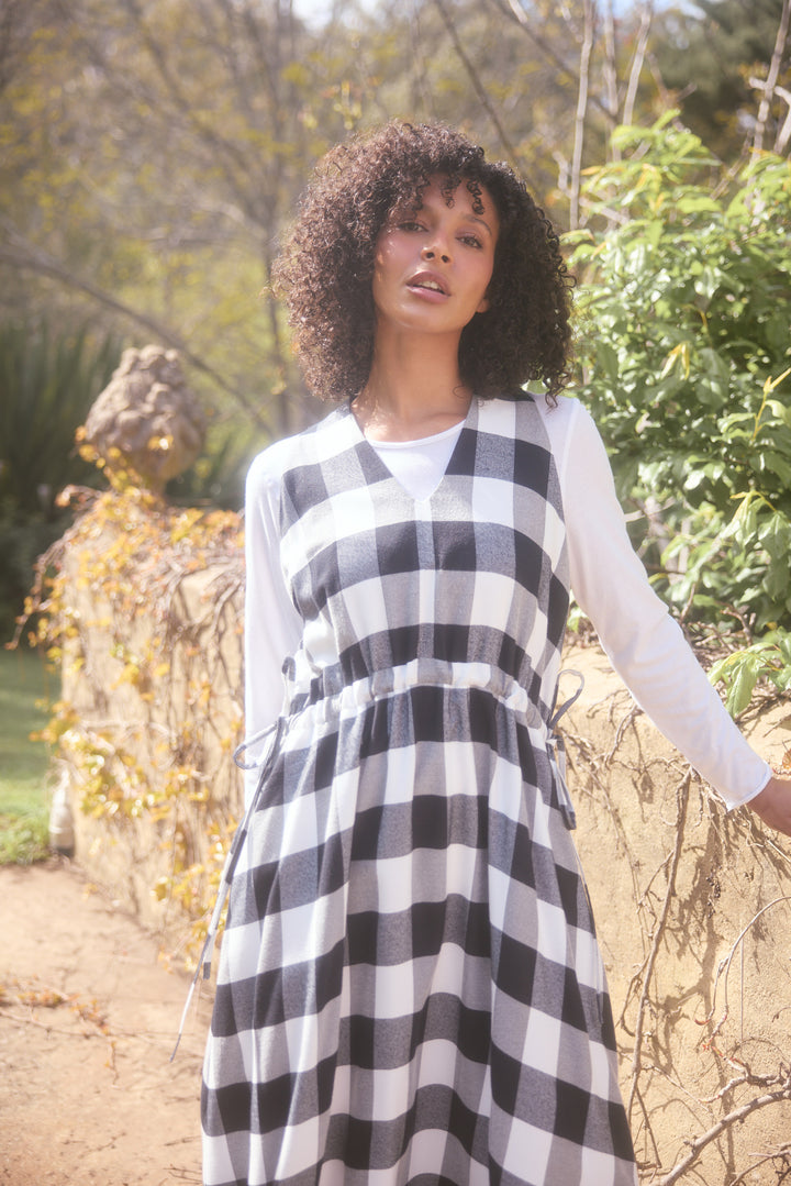 Woman wearing a black and white checkered dress in an outdoor setting