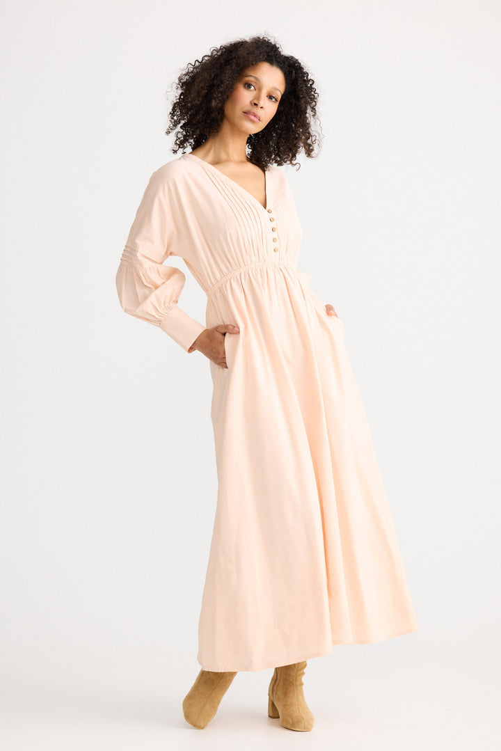 Woman wearing a light pink dress on a white background