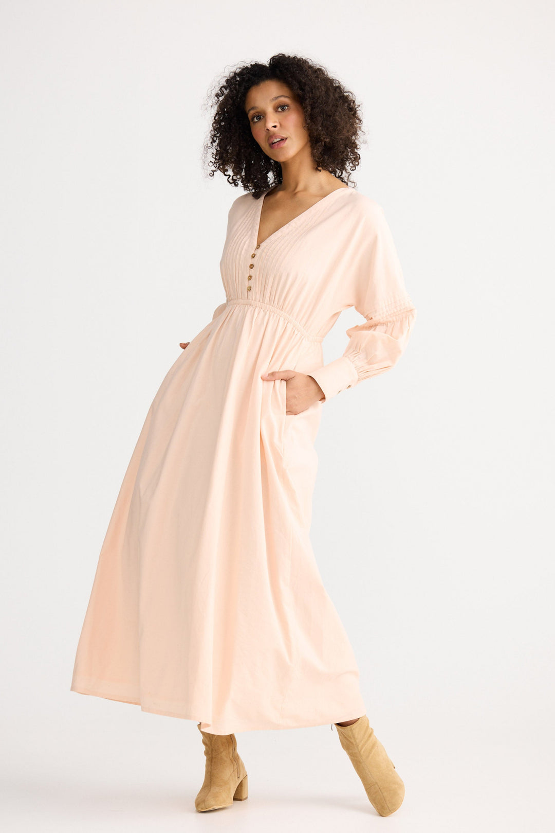 Woman wearing a light pink dress on a white background