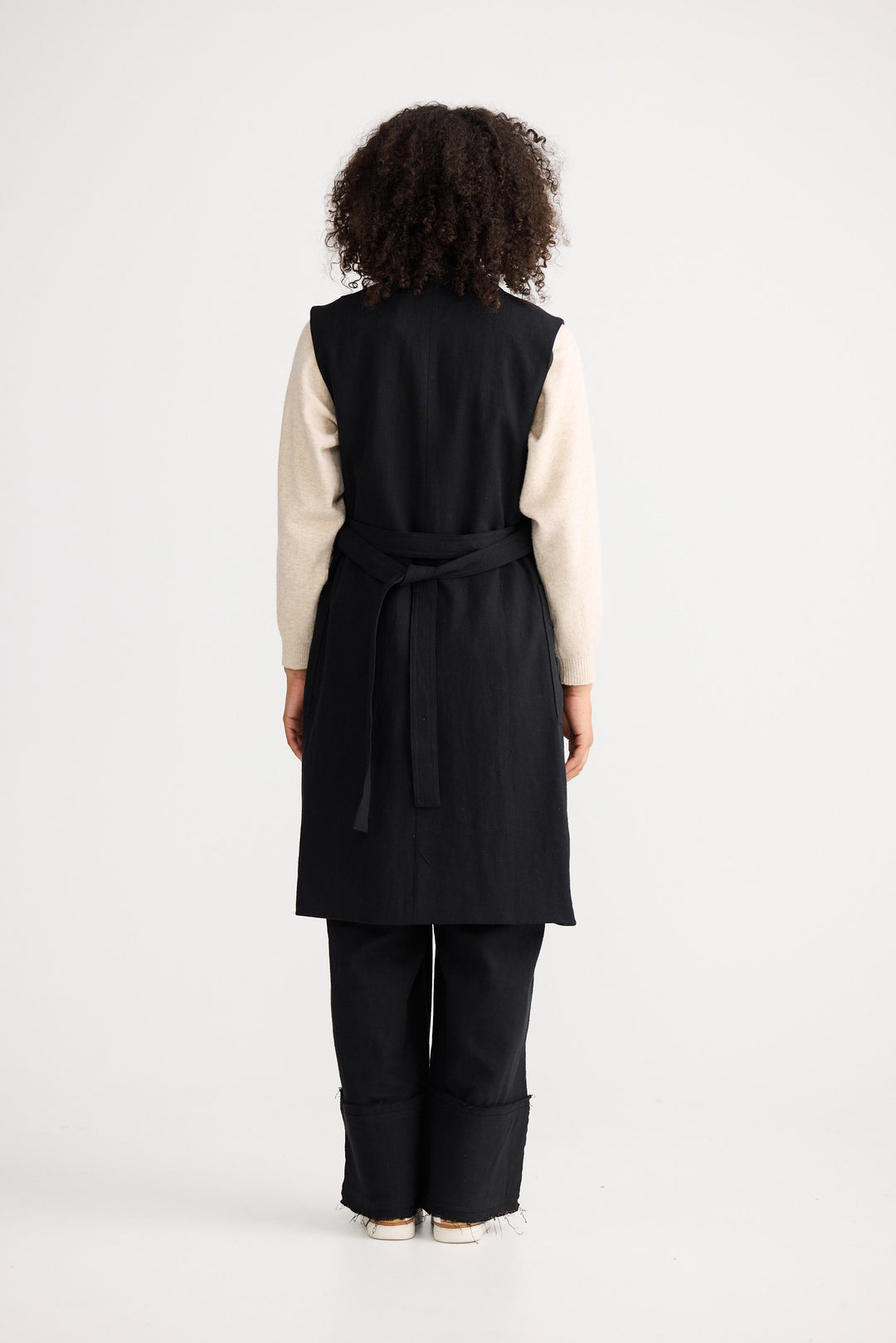 Model wearing black Noa Vest, back view on white background