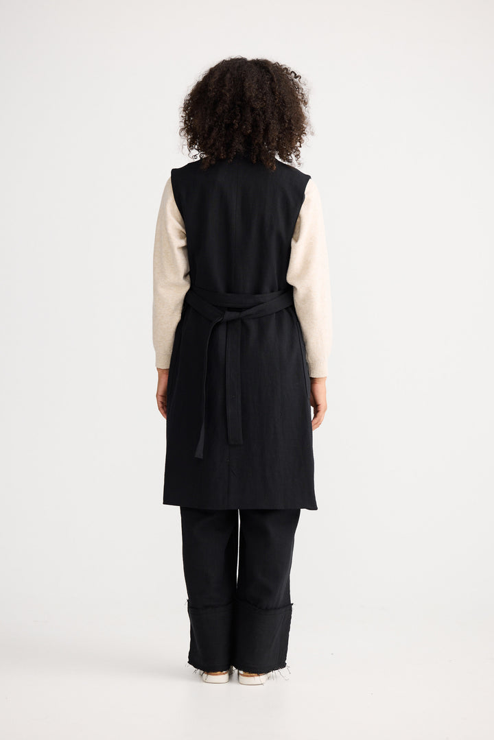 Model wearing black Noa Vest, back view on white background