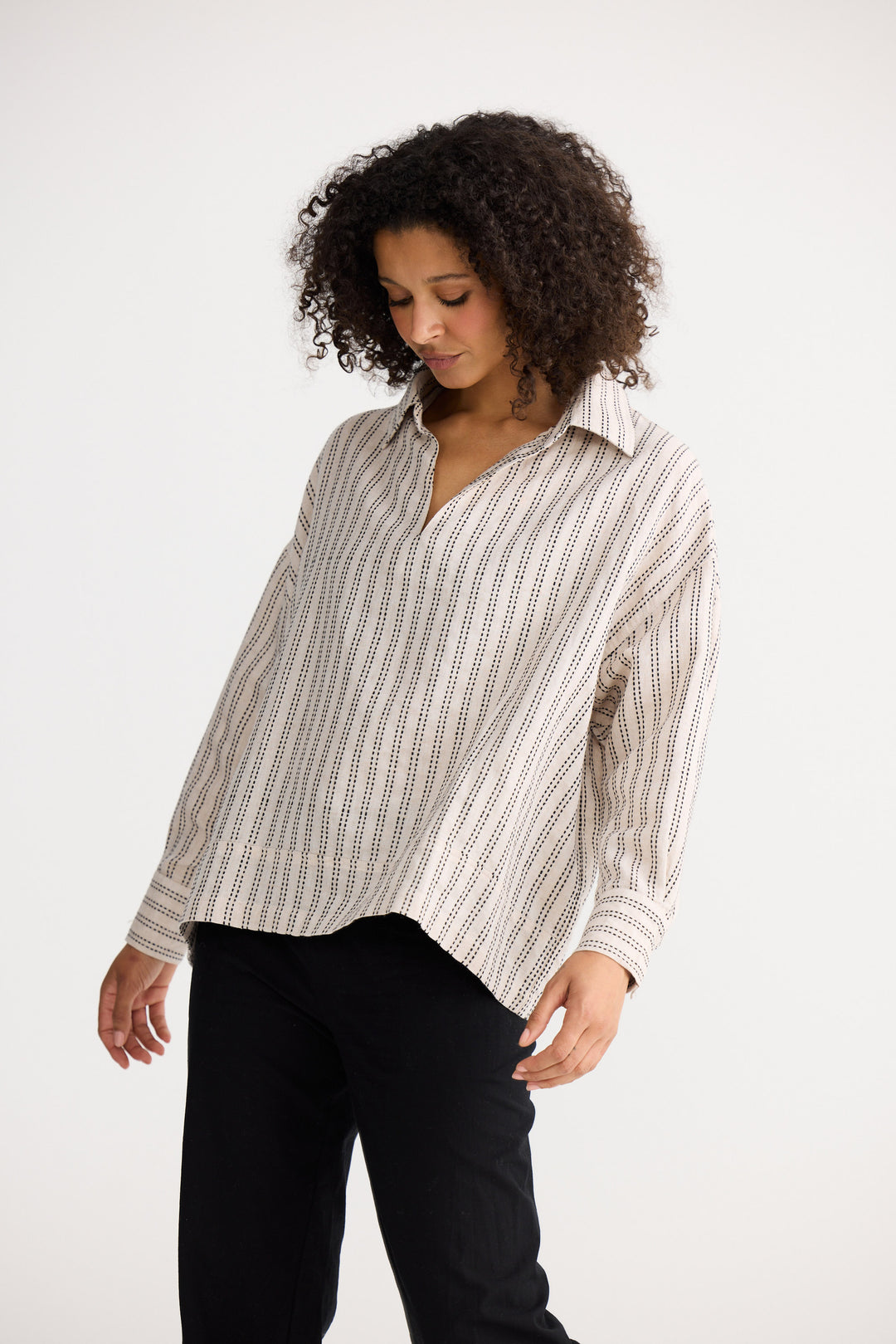 Model wearing natural stitch Wander Long Sleeve Top, side view on white background
