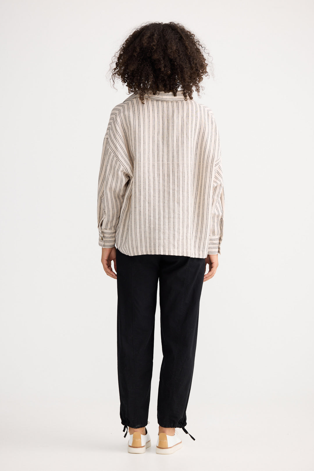 Model wearing natural stitch Wander Long Sleeve Top, back view on white background