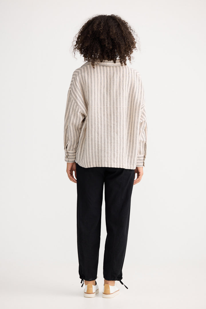 Model wearing natural stitch Wander Long Sleeve Top, back view on white background