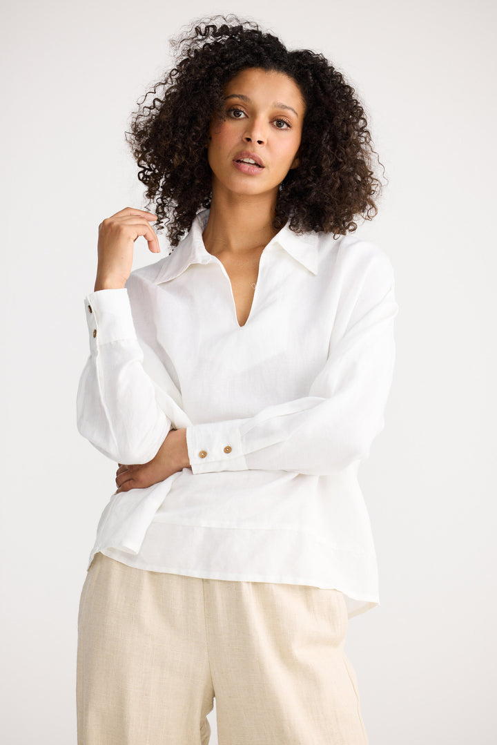 Woman wearing a white blouse with a plain background