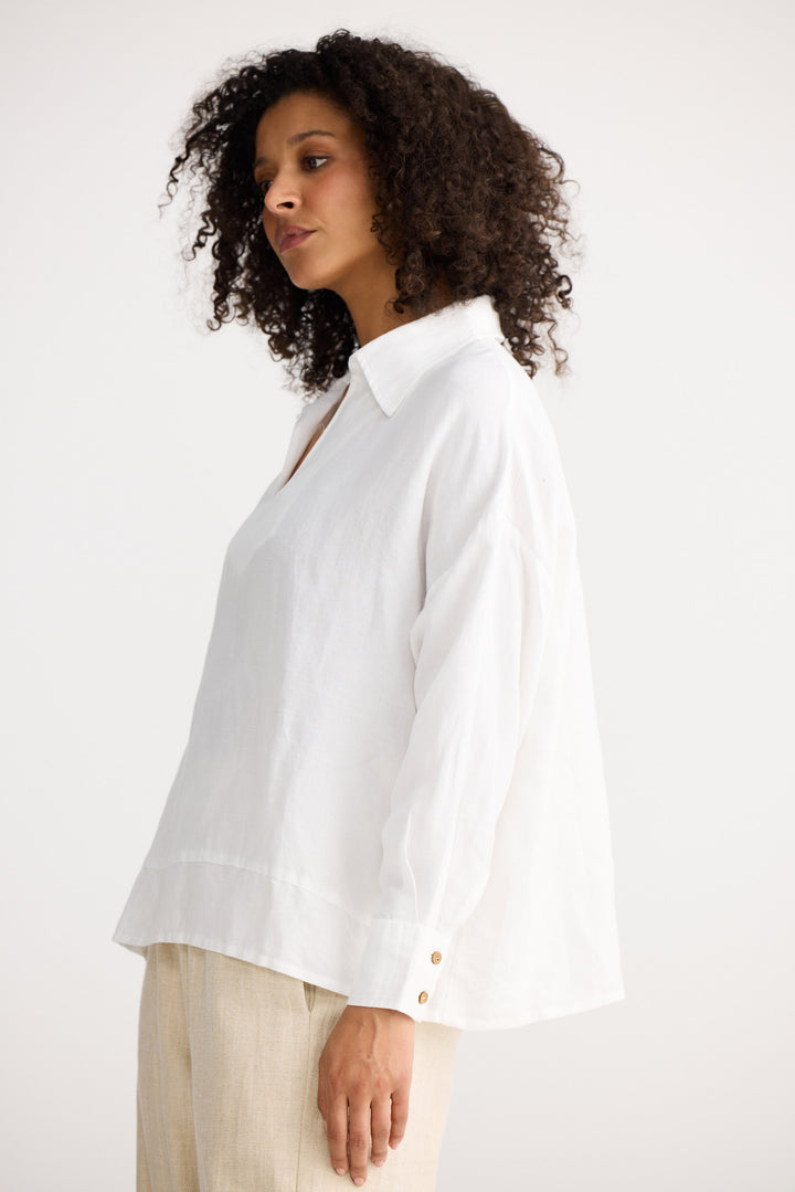 Woman wearing a white blouse with a plain background