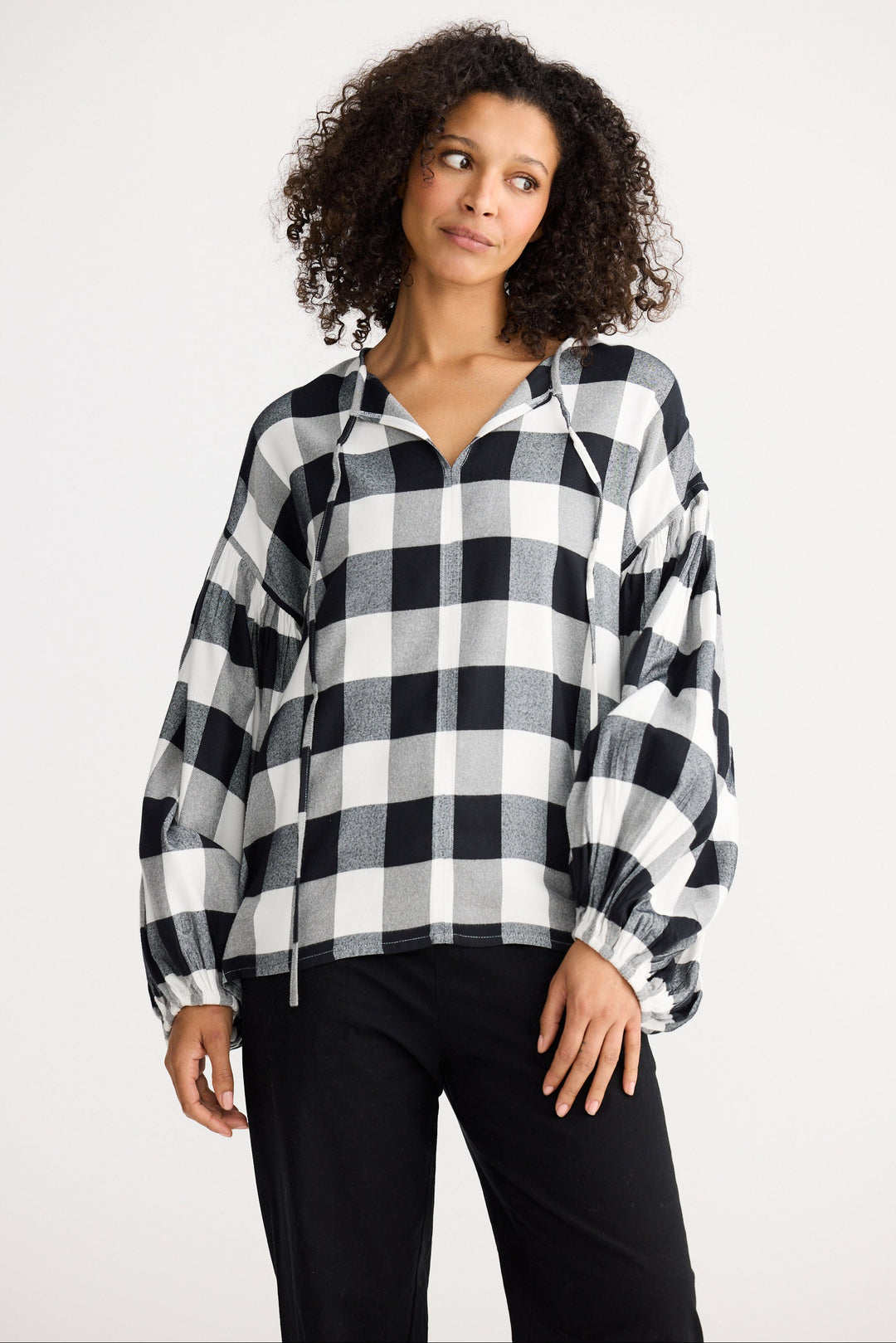 Woman wearing a black and white checkered shirt against a white background