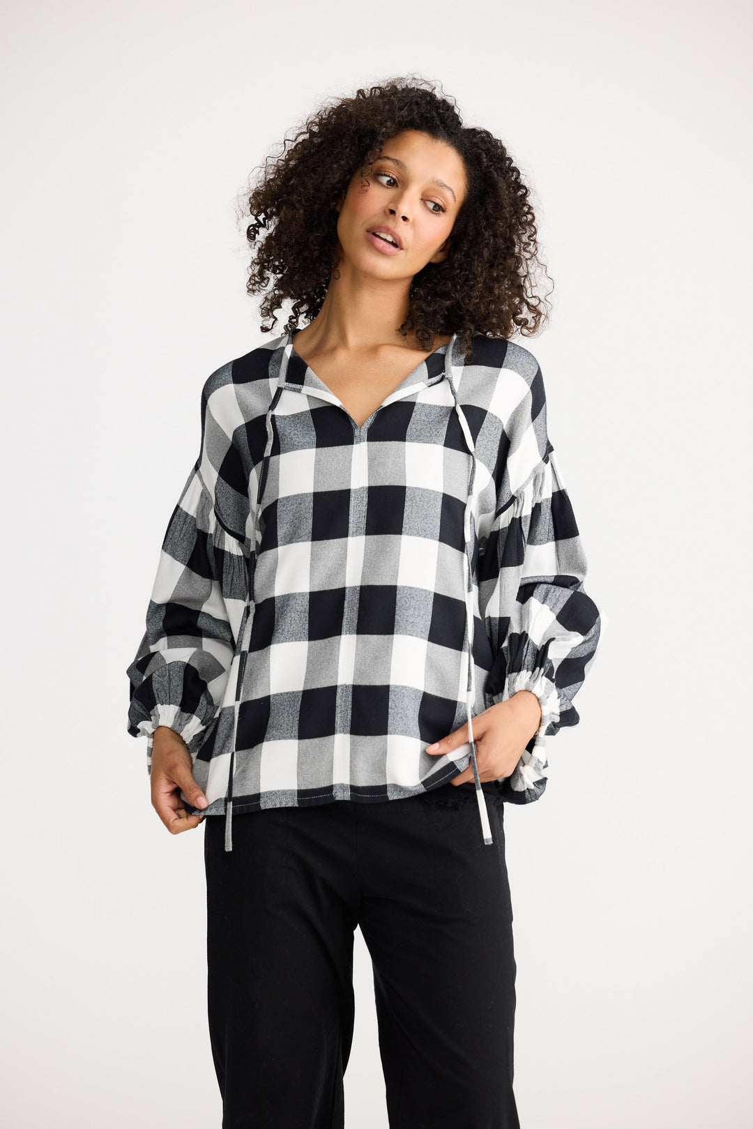 Woman wearing a black and white checkered shirt on a white background
