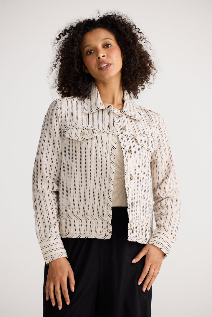 Model wearing natural stitch Monza Jacket, side view on white background
