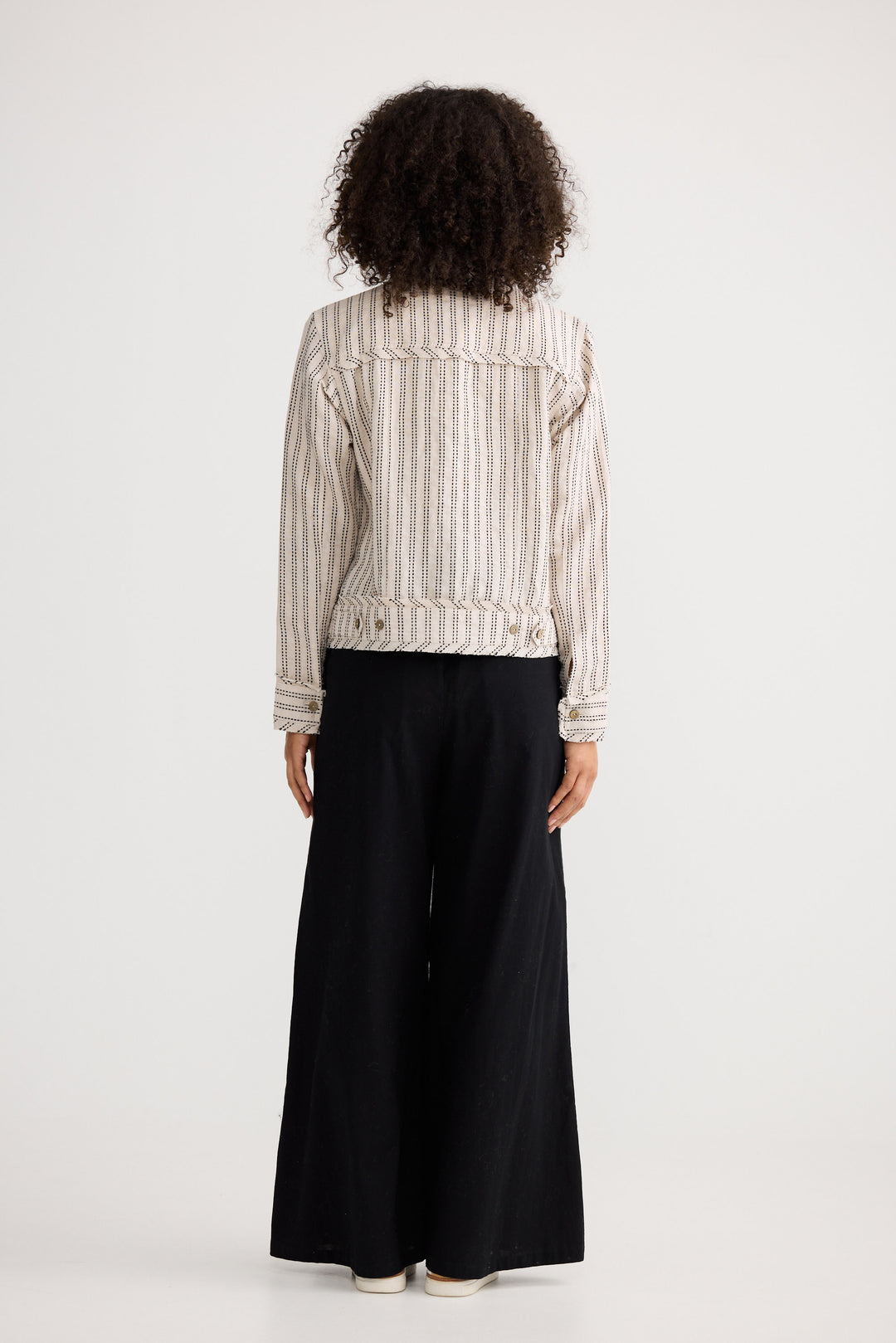 Model wearing natural stitch Monza Jacket, back view on white background