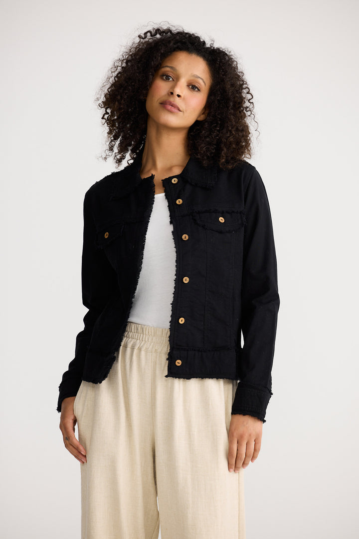 Woman wearing a black jacket with gold buttons on a white background