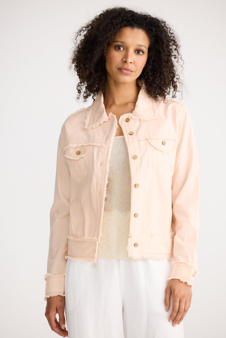 Woman wearing a light pink denim jacket on a white background