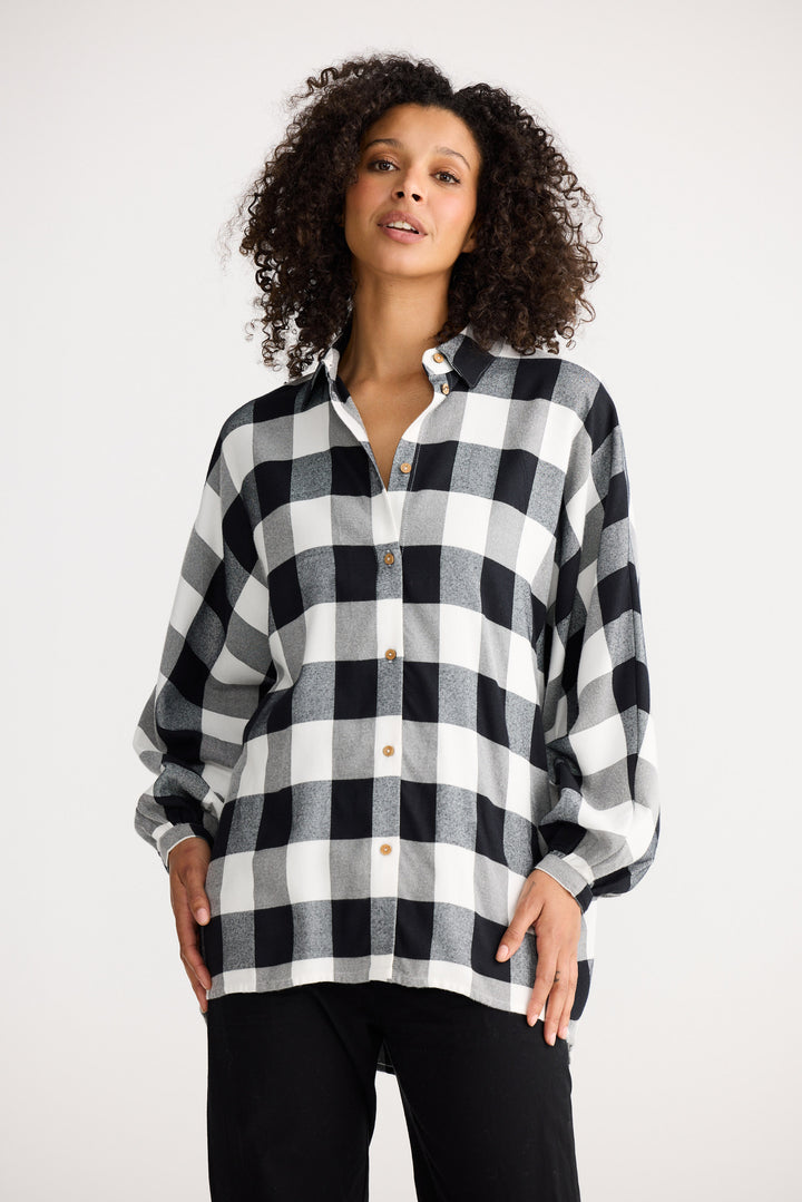 Woman wearing a black and white checkered shirt on a white background