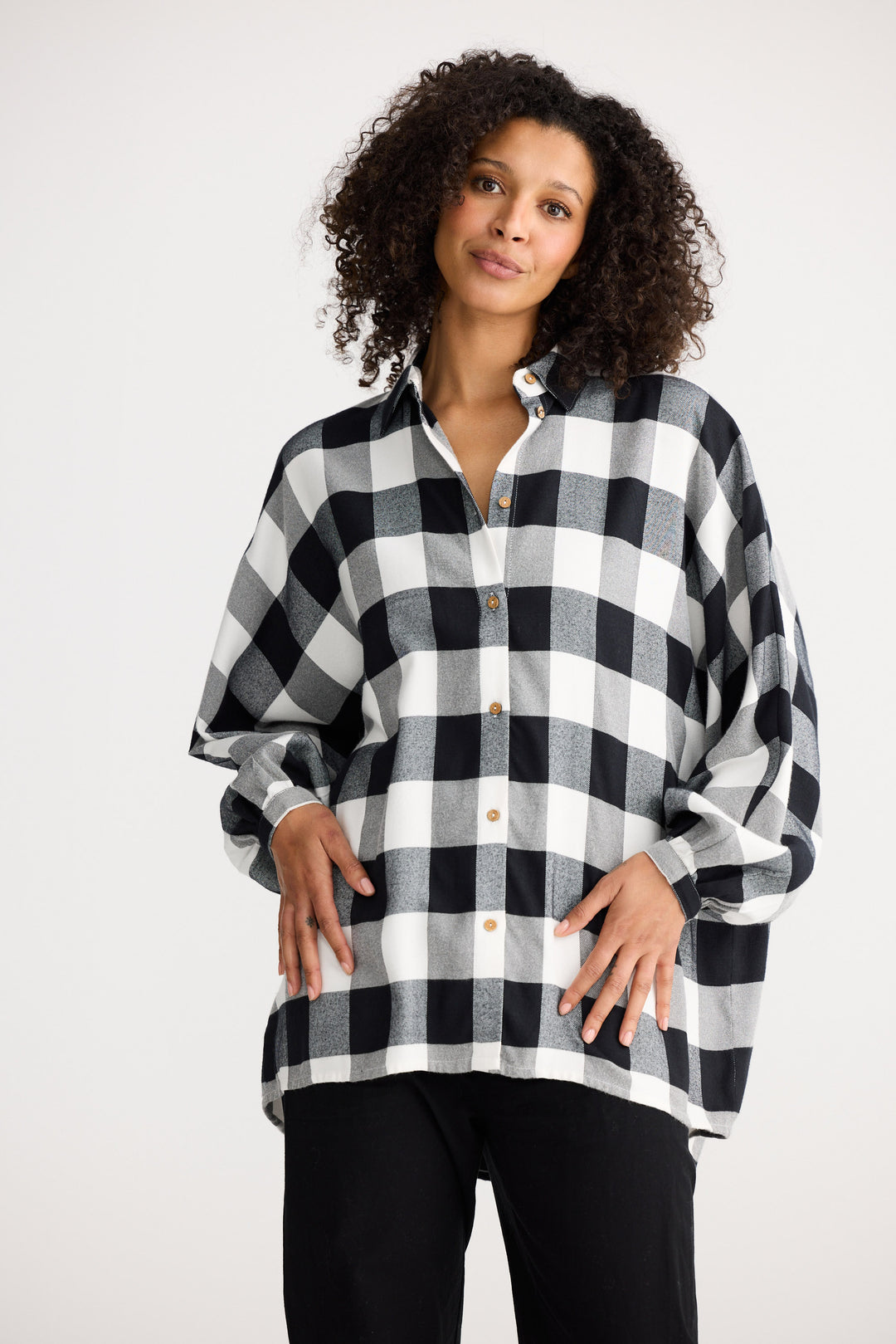 Woman wearing a black and white checkered shirt against a white background