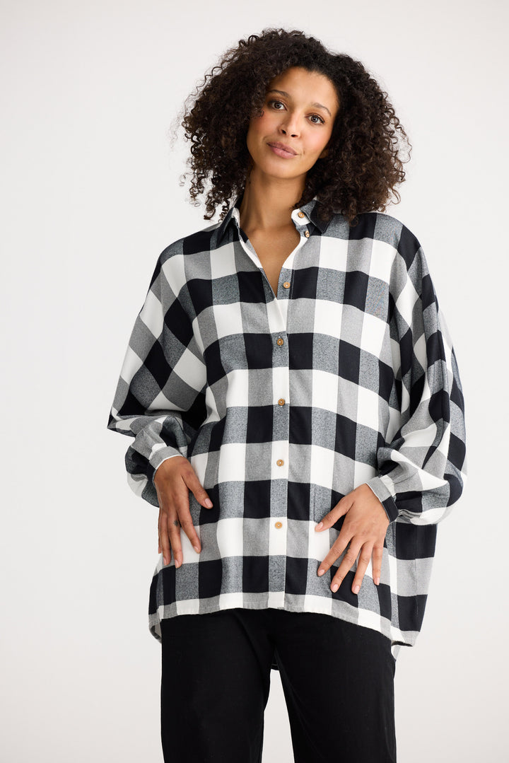 Woman wearing a black and white checkered shirt against a white background