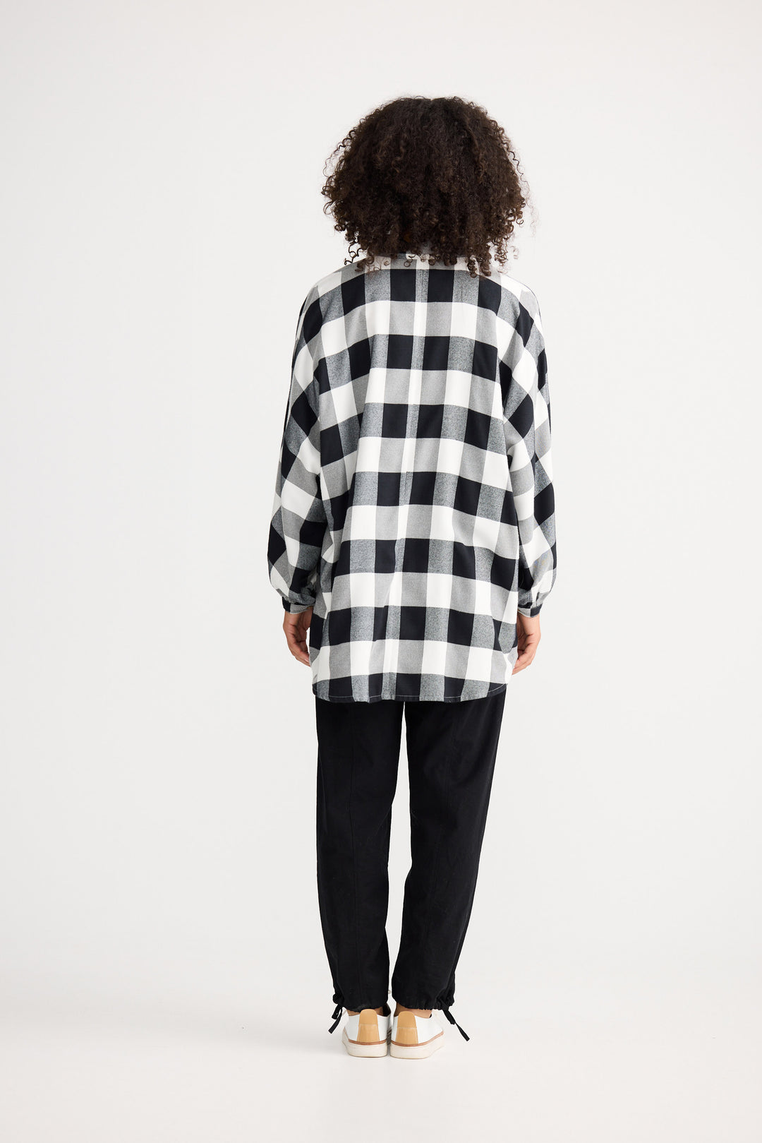 Person wearing a black and white checkered shirt on a white background