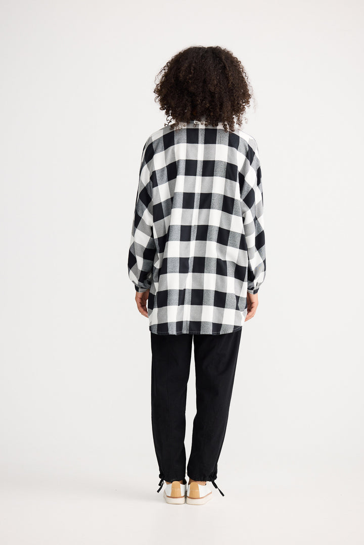 Person wearing a black and white checkered shirt on a white background