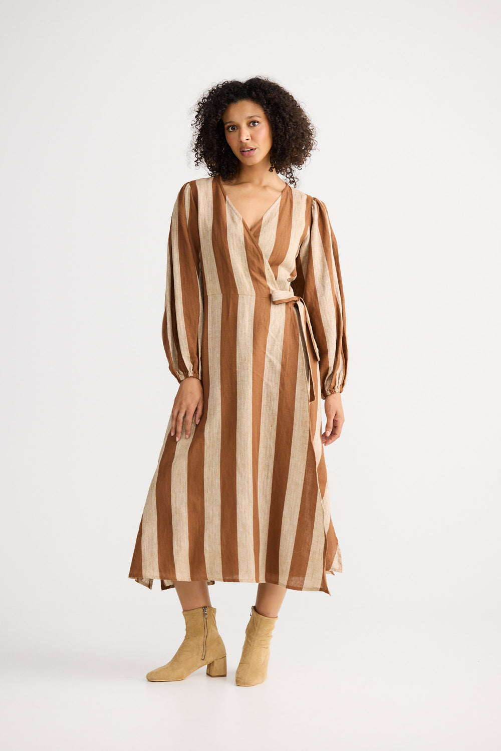 Woman wearing a brown and beige striped dress on a white background