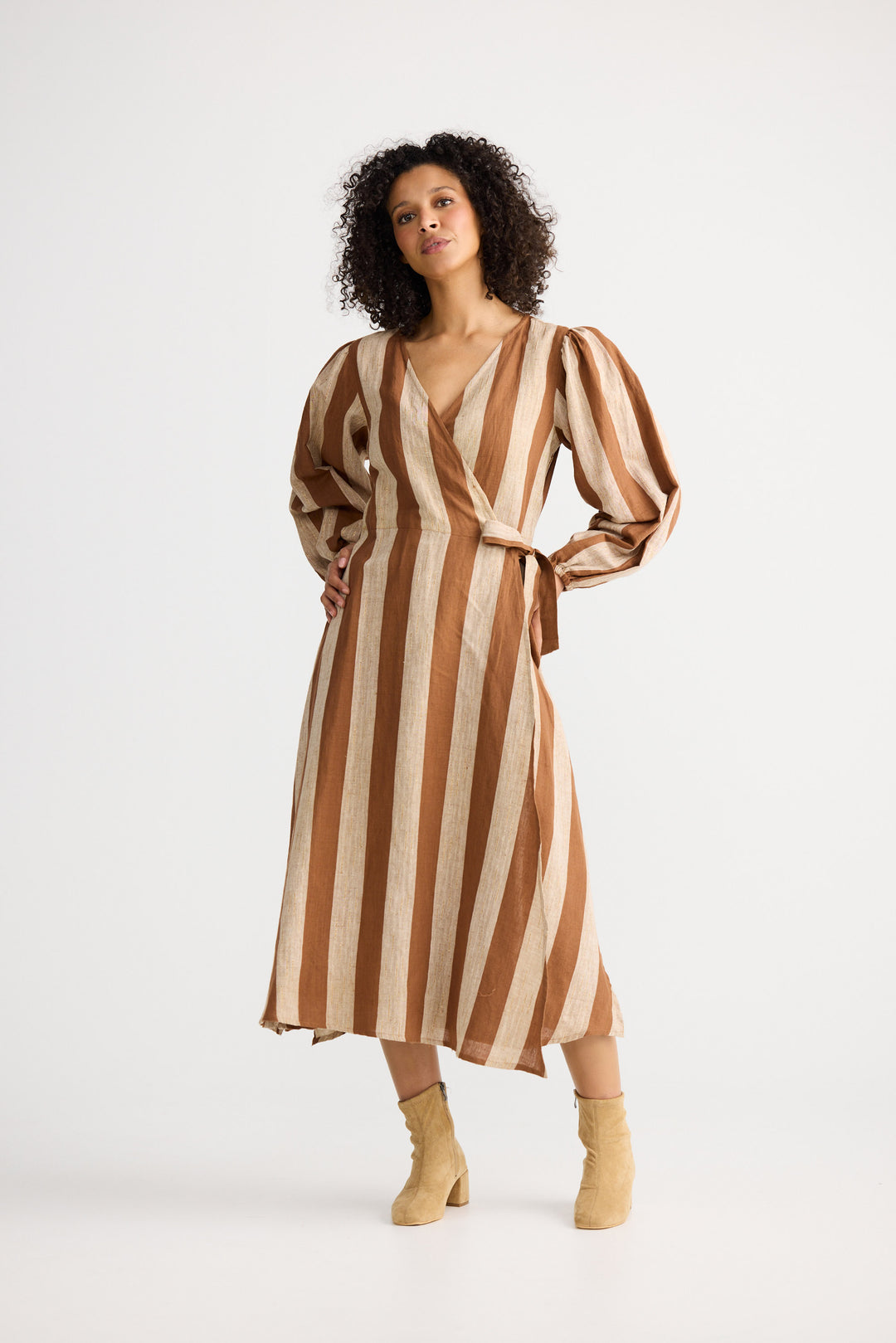 Woman wearing a brown and beige striped dress on a white background