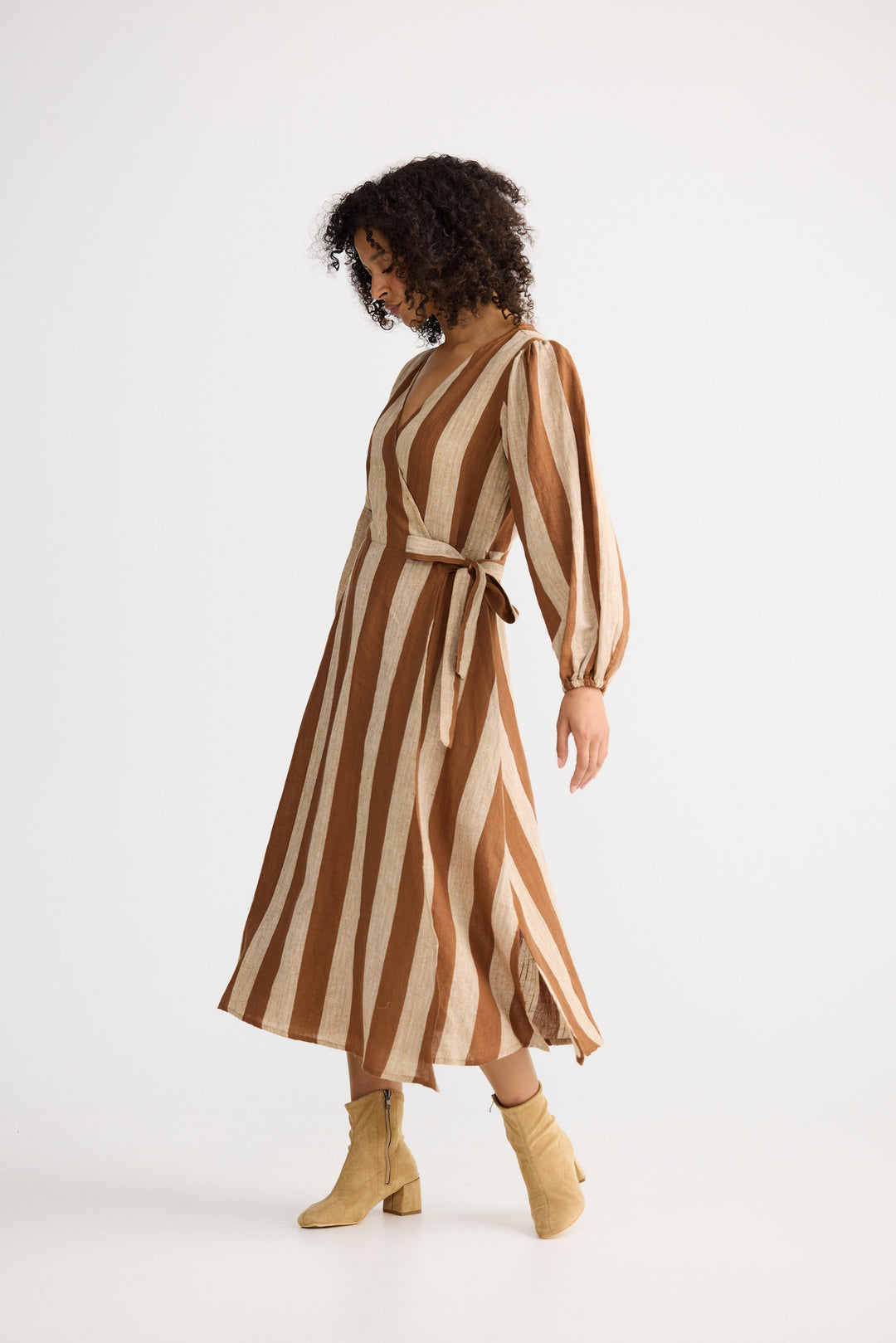 Woman wearing a brown and beige striped dress on a white background