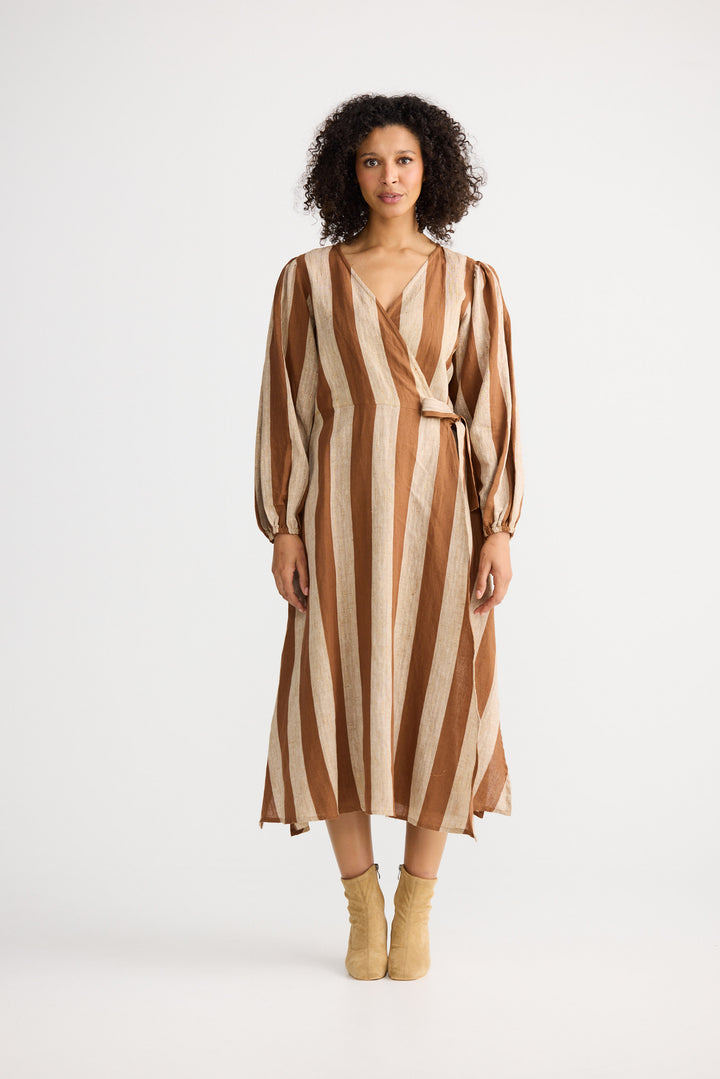 Woman wearing a brown and beige striped dress on a white background