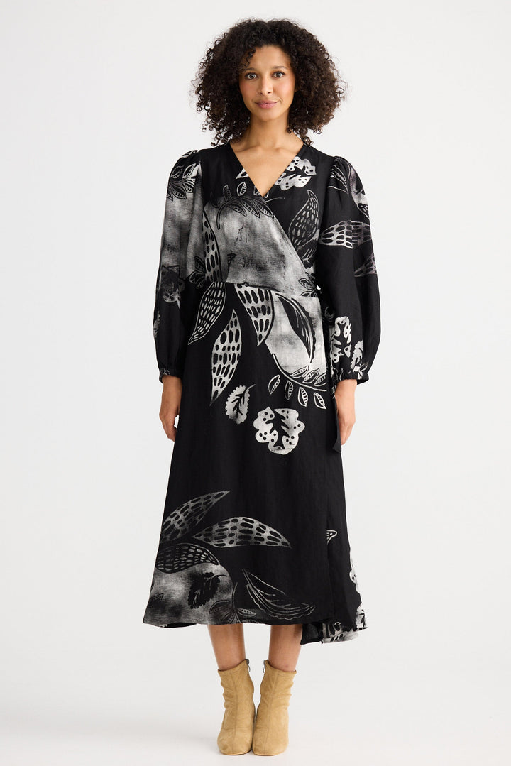 Woman wearing a black dress with white floral patterns on a white background