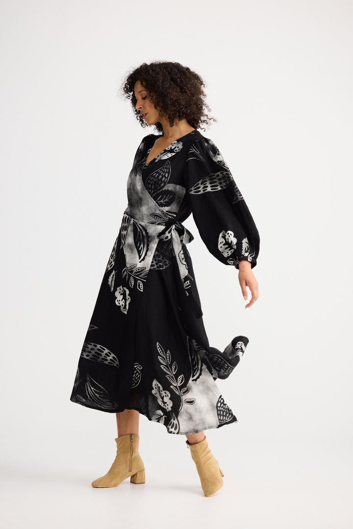 Woman wearing a black floral dress on a white background