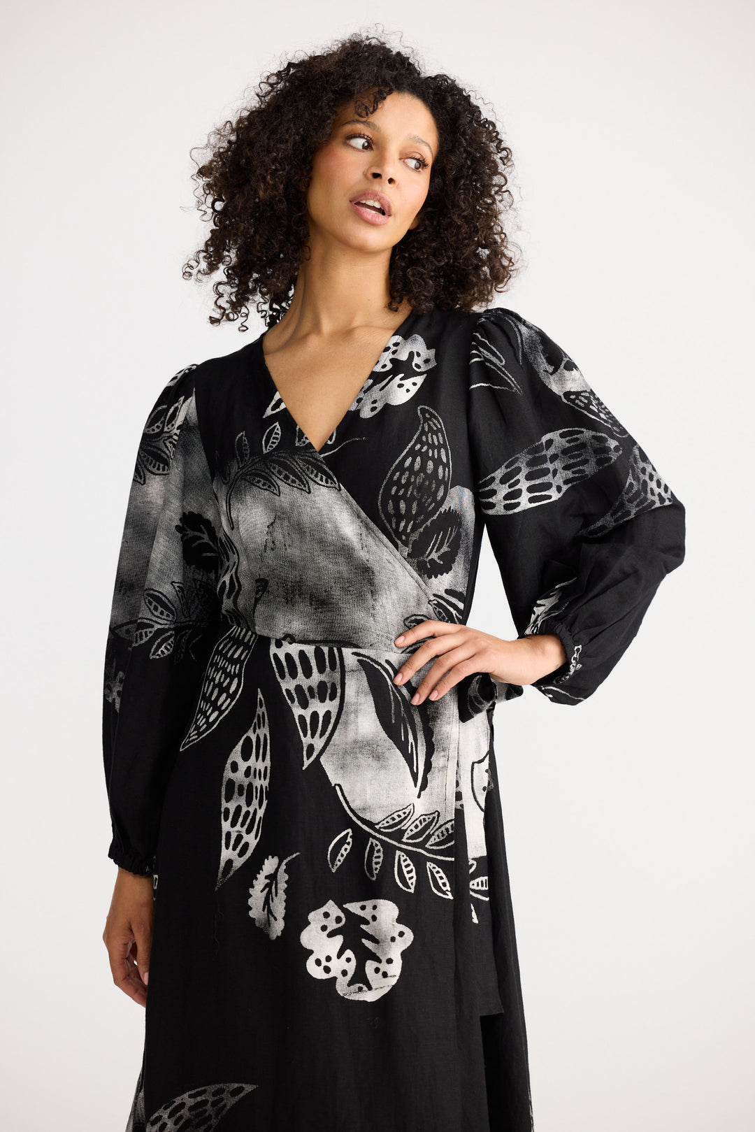 Woman wearing a black floral patterned dress against a white background