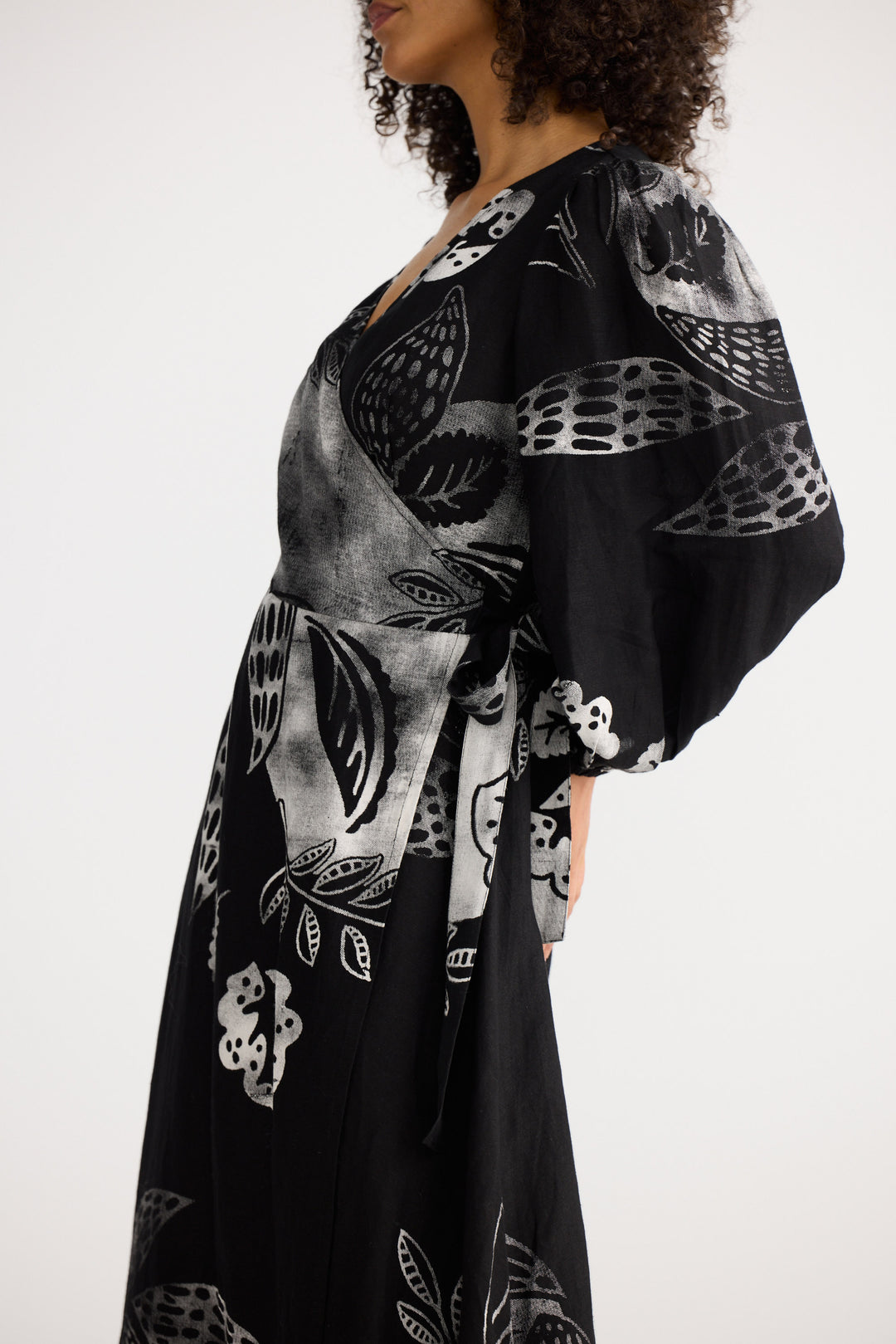 Woman wearing a black kimono-style garment with white and gray abstract patterns on a white background