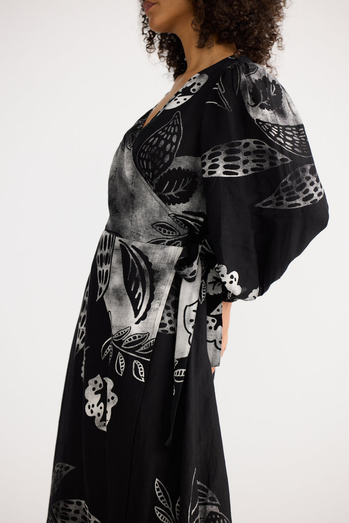 Woman wearing a black kimono-style garment with white and gray abstract patterns on a white background