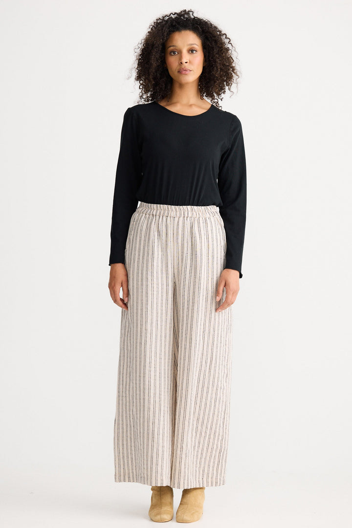 Model wearing natural stitch Positano Pant, front view on white background