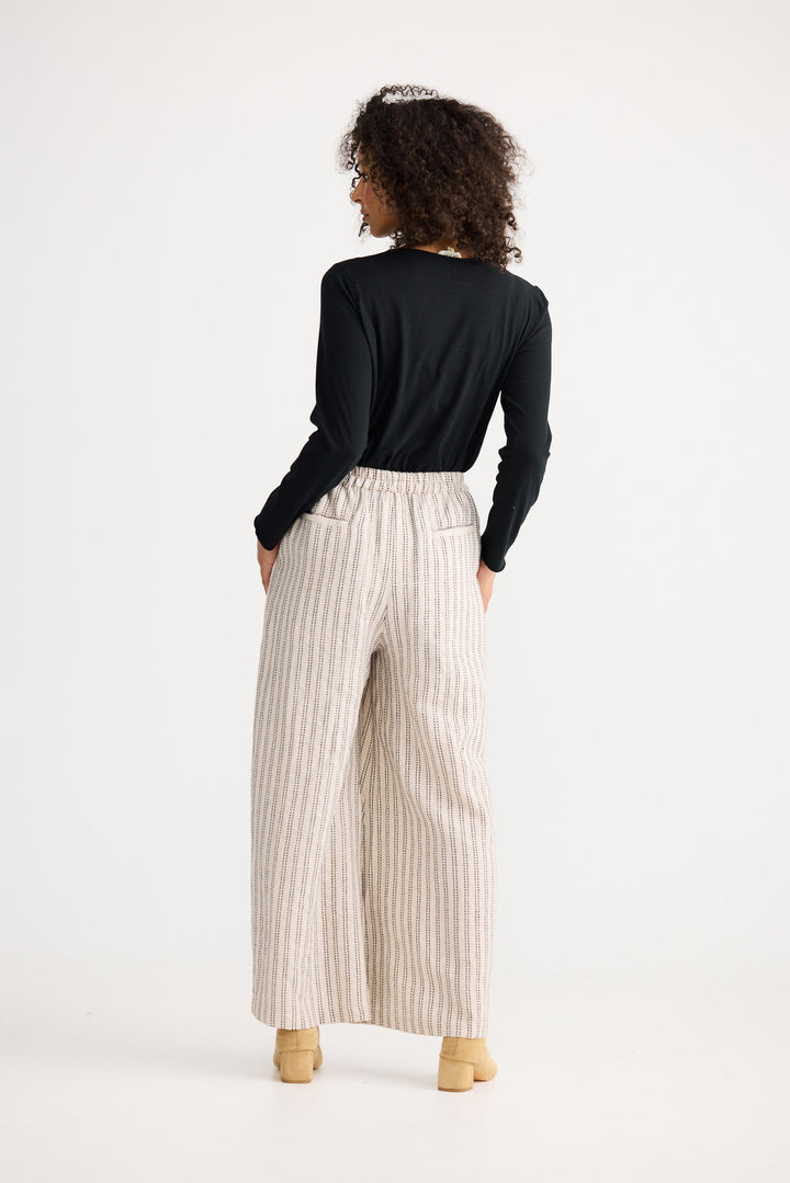 Model wearing natural stitch Positano Pant, back view on white background