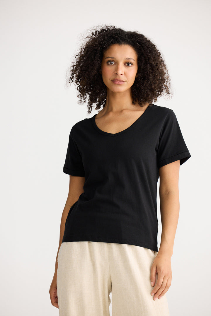 Model wearing black Kasai Short Sleeve Tee, side view on white background