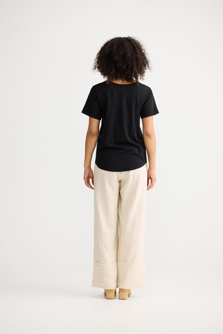Model wearing black Kasai Short Sleeve Tee, back view on white background