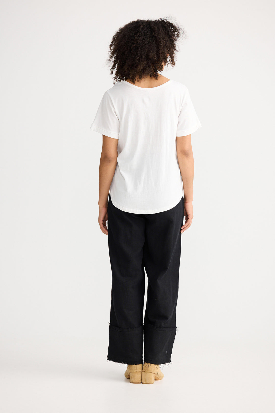 Model wearing ivory Kasai Short Sleeve Tee, side view on white background