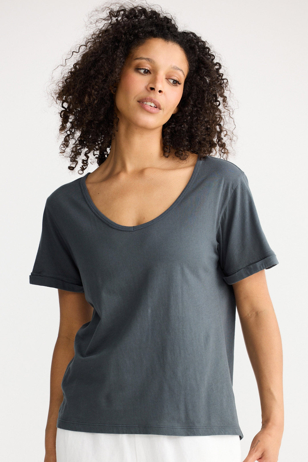 Model wearing slate Kasai Short Sleeve Tee, front view on white background