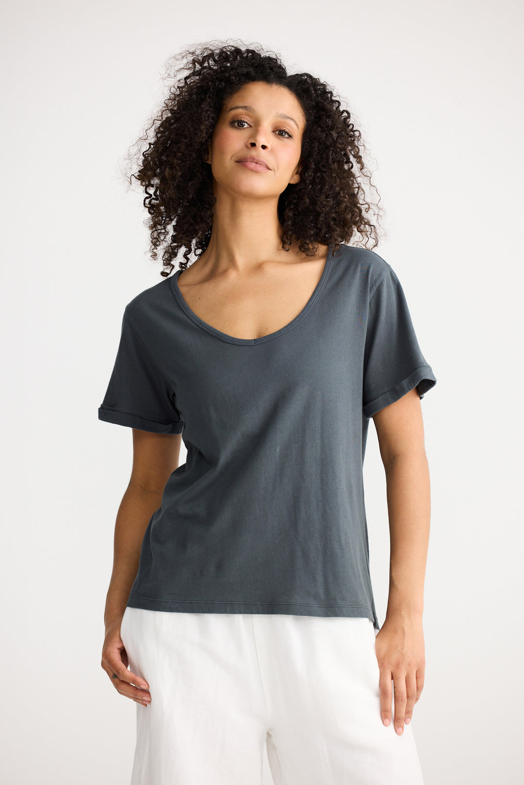Model wearing slate Kasai Short Sleeve Tee, side view on white background