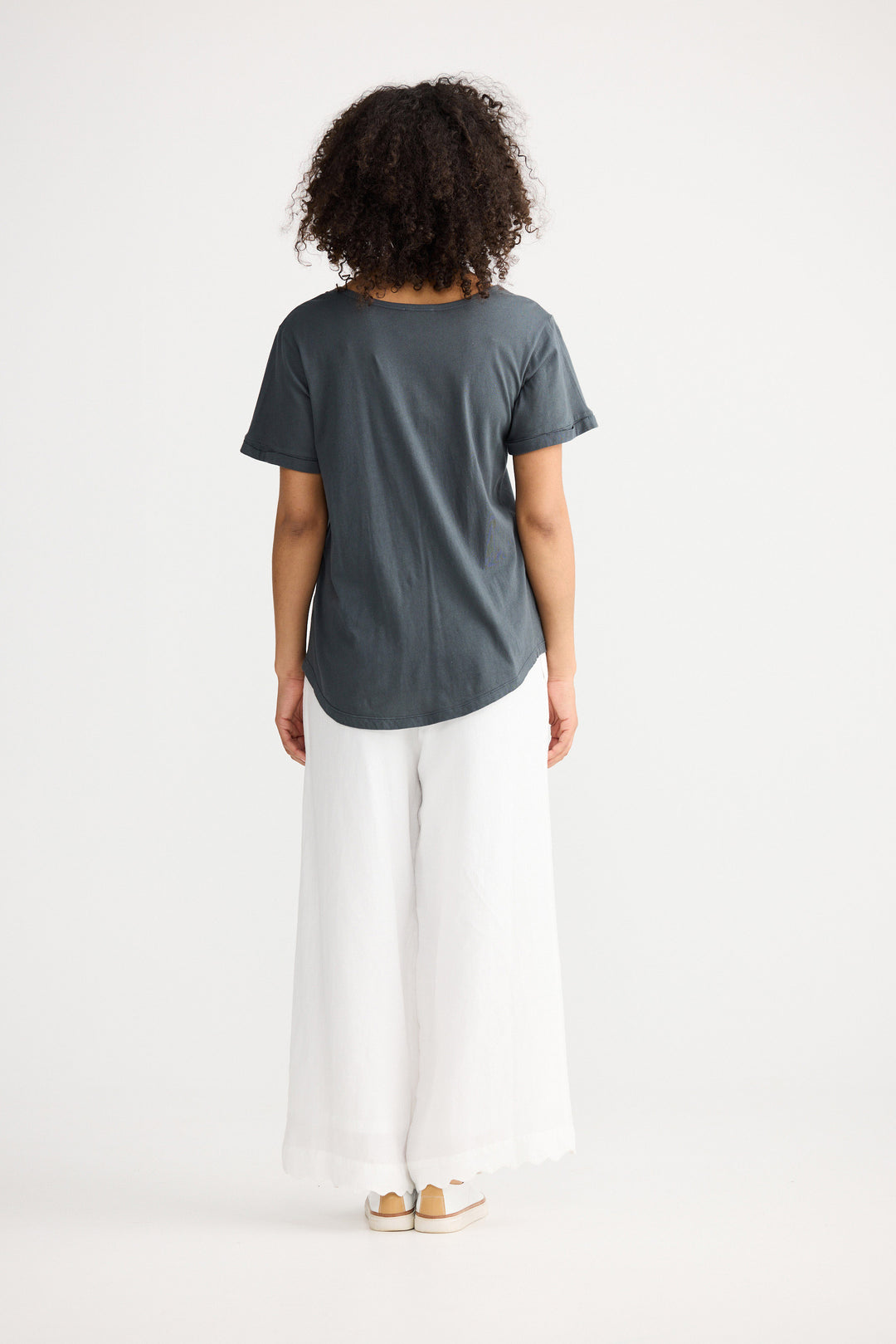 Model wearing slate Kasai Short Sleeve Tee, back view on white background
