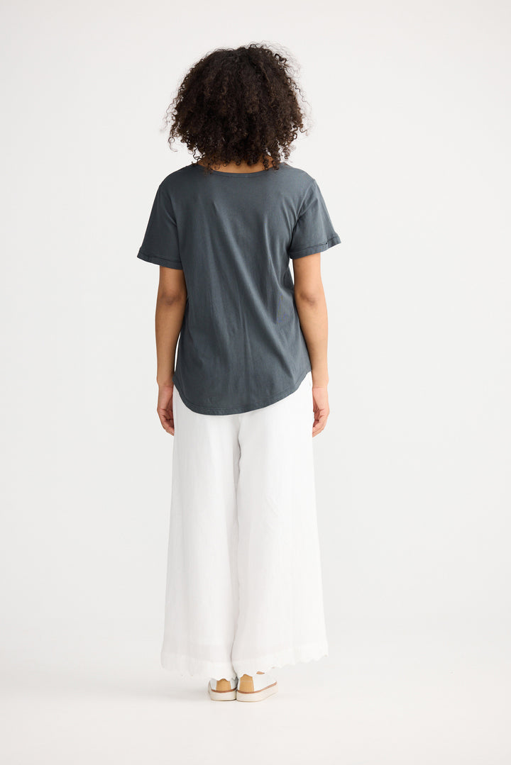 Model wearing slate Kasai Short Sleeve Tee, back view on white background