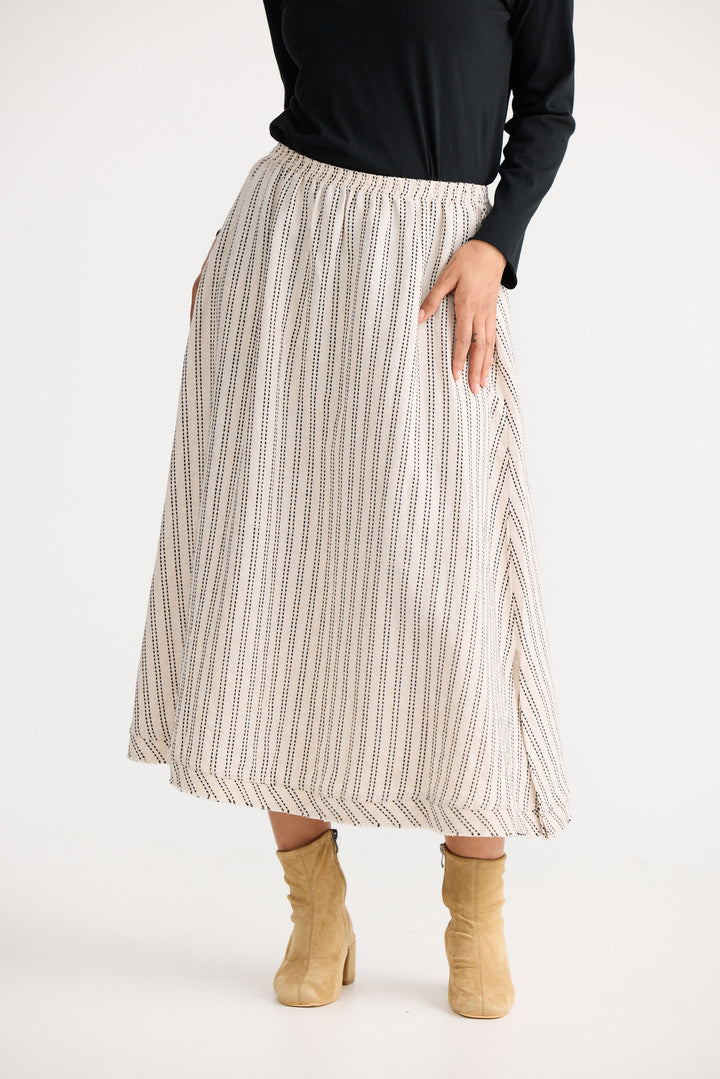 Person wearing a striped skirt with a plain background