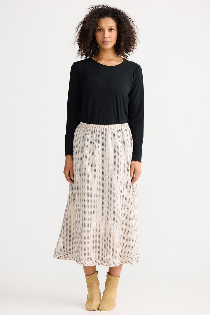 Woman wearing a black top and striped skirt on a white background