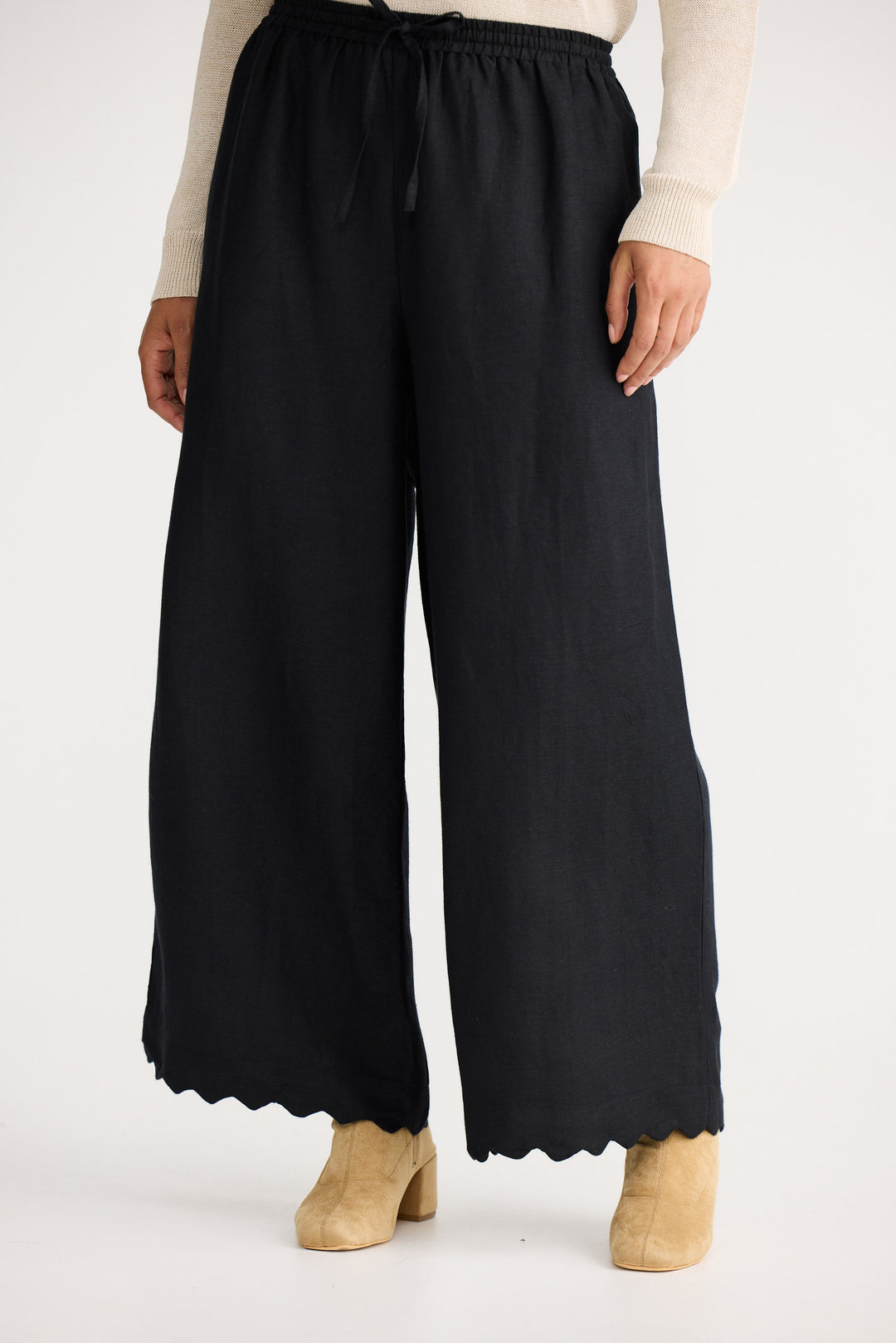 Black wide-leg pants worn by a person on a white background