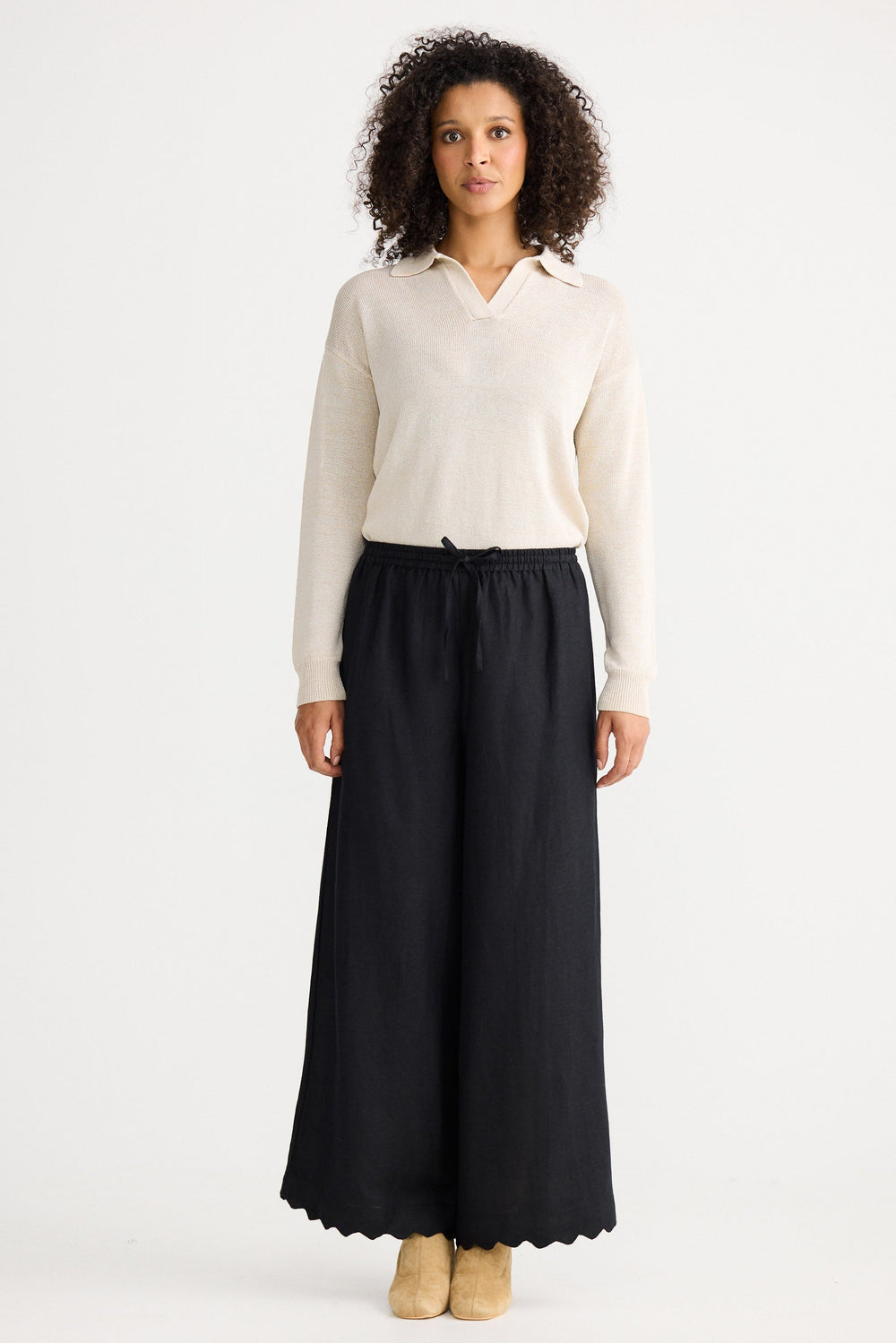 Woman wearing a white blouse and black skirt on a white background